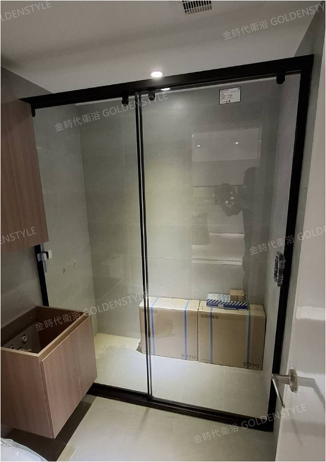 本案採用 黑色鋁框吊掛式滑門淋浴拉門，以俐落線條搭配大面積強化玻璃，讓浴室視覺更開闊，同時兼顧美觀與實用性。